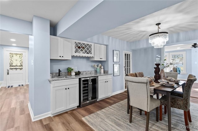 13130 The Glebe Ln, Charles City, VA 23030 - dining area featuring beverage cooler, light wood-style floors, bar area, baseboards, and a ceiling fan