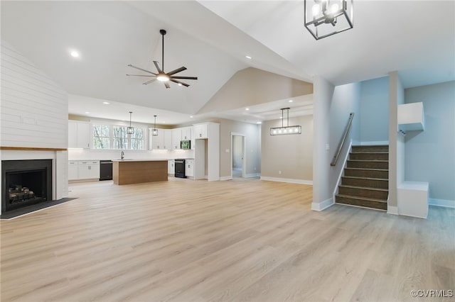 unfurnished living room with stairs, recessed lighting, baseboards, a ceiling fan, and a large fireplace