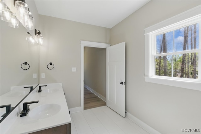 full bathroom with baseboards, tile patterned floors, and double vanity