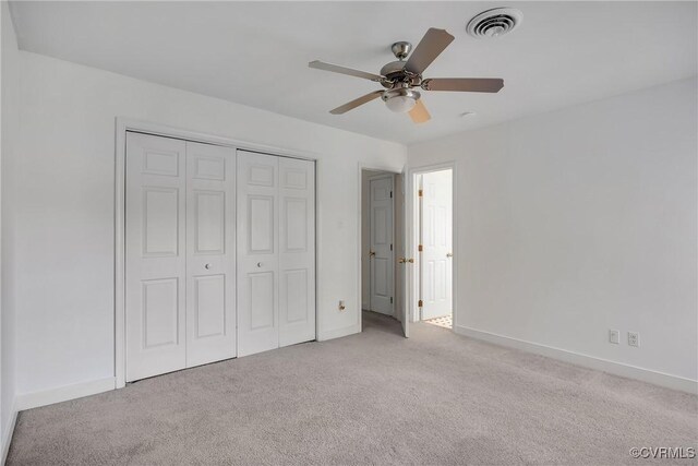 unfurnished bedroom featuring carpet floors, baseboards, a closet, and ceiling fan