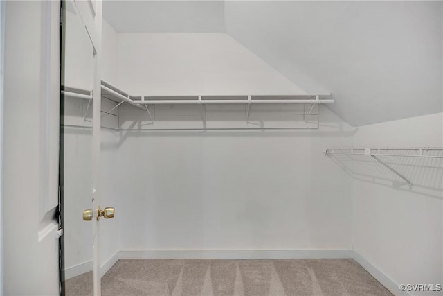 walk in closet featuring carpet floors and vaulted ceiling