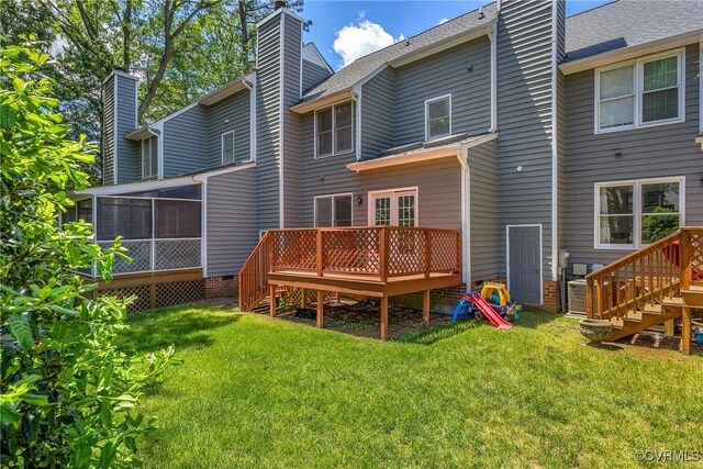 rear view of property featuring a chimney, stairs, a wooden deck, and a sunroom