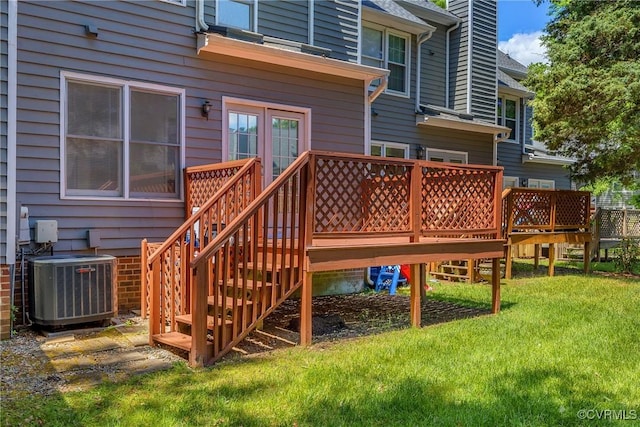 deck with central AC, a lawn, and stairs
