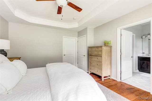 10527 Deerlake Dr, New Kent, VA 23124 - bedroom with light wood-type flooring, a tray ceiling, connected bathroom, ceiling fan, and crown molding