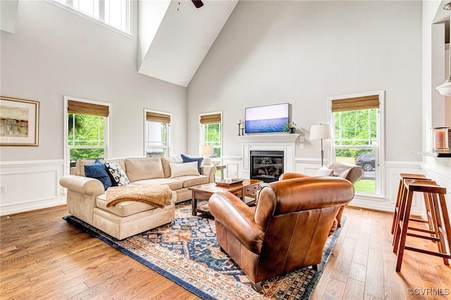 10527 Deerlake Dr, New Kent, VA 23124 - living area with high vaulted ceiling, healthy amount of natural light, hardwood / wood-style floors, a glass covered fireplace, and wainscoting