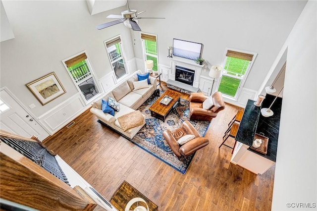 10527 Deerlake Dr, New Kent, VA 23124 - living area featuring a towering ceiling, wood finished floors, a decorative wall, wainscoting, and a ceiling fan