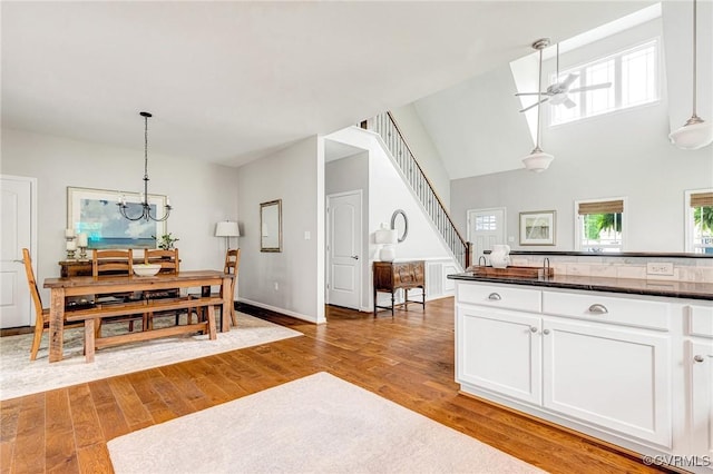 10527 Deerlake Dr, New Kent, VA 23124 - dining area with ceiling fan, wood finished floors, a chandelier, stairway, and baseboards