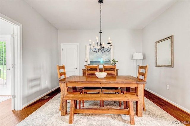 10527 Deerlake Dr, New Kent, VA 23124 - dining area featuring a chandelier, wood finished floors, and baseboards
