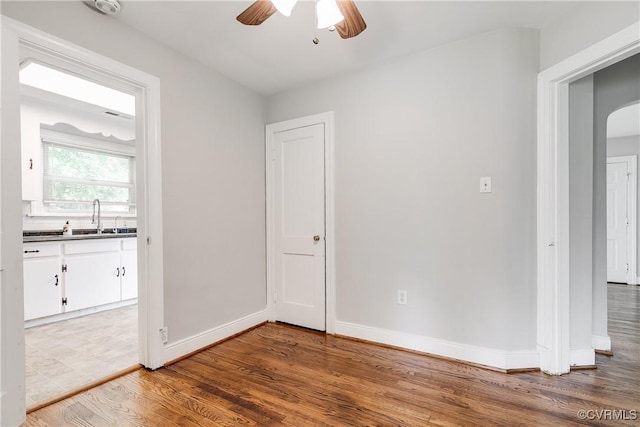 2704 Carlisle Ave, Henrico, VA 23231 - empty room featuring arched walkways, a ceiling fan, a sink, wood finished floors, and baseboards