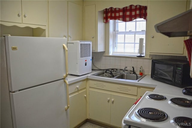 kitchen with white appliances, light countertops, a sink, and backsplash