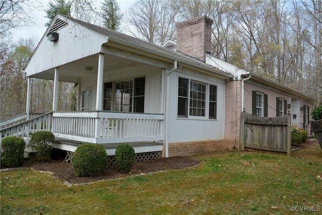 view of home's exterior with a chimney and a porch