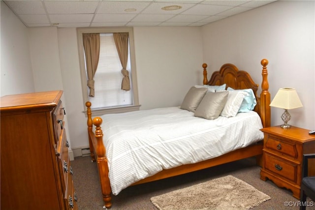 bedroom featuring carpet, a paneled ceiling, and a baseboard heating unit