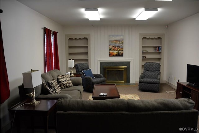 living room with built in features, a glass covered fireplace, carpet floors, and baseboards