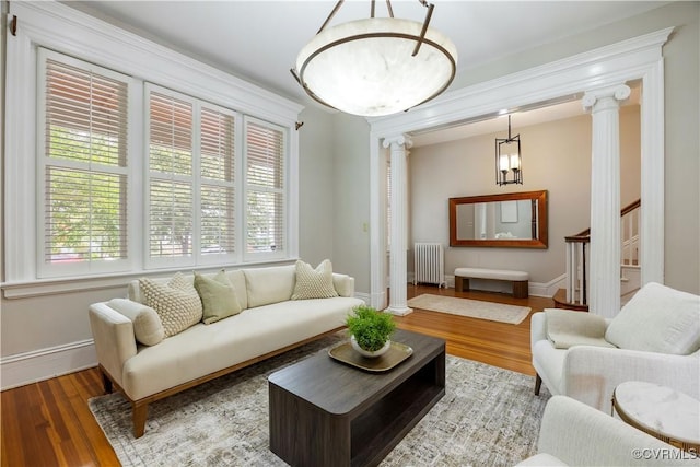 2706 W Grace St, Richmond, VA 23220 - living area featuring radiator heating unit, ornate columns, baseboards, and wood finished floors