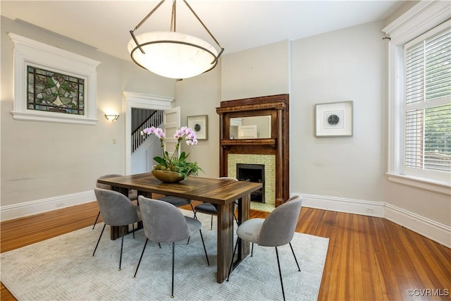 2706 W Grace St, Richmond, VA 23220 - dining area featuring baseboards, wood finished floors, and a fireplace with flush hearth