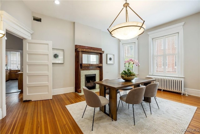 2706 W Grace St, Richmond, VA 23220 - dining room with radiator heating unit, baseboards, wood finished floors, and a fireplace
