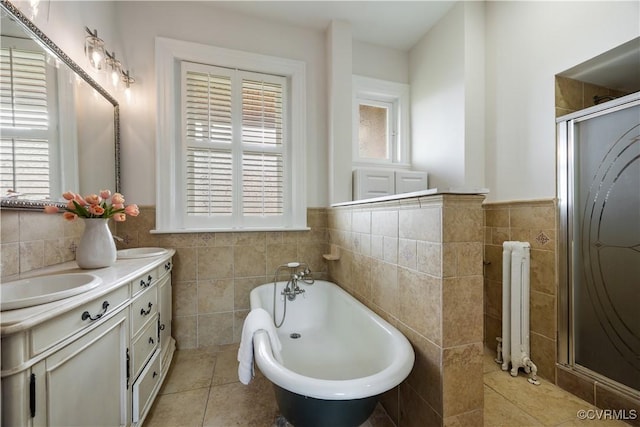 2706 W Grace St, Richmond, VA 23220 - full bath with tile walls, radiator heating unit, a tub to relax in, a shower stall, and tile patterned flooring