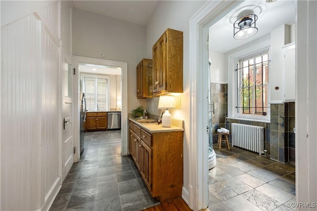 2706 W Grace St, Richmond, VA 23220 - kitchen with radiator heating unit, stainless steel appliances, brown cabinets, light countertops, and a sink