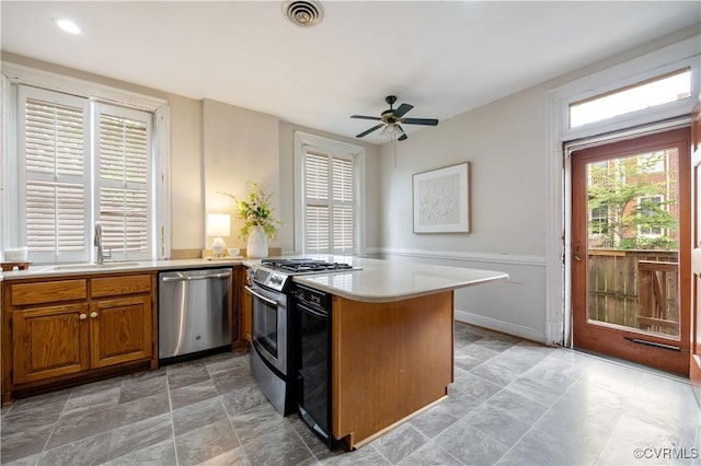2706 W Grace St, Richmond, VA 23220 - kitchen with appliances with stainless steel finishes, a peninsula, light countertops, a sink, and ceiling fan