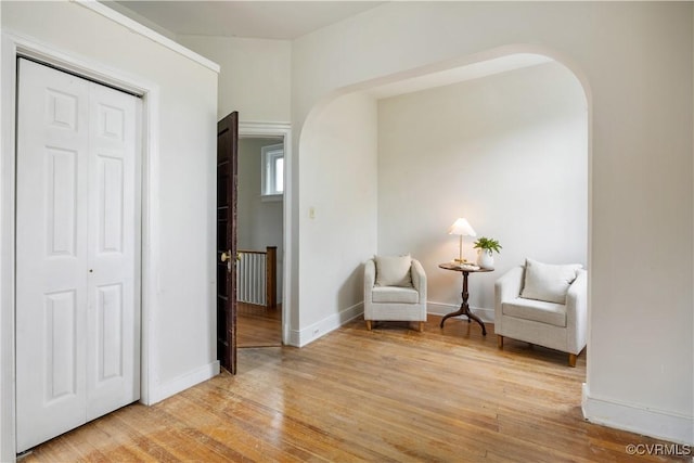 2706 W Grace St, Richmond, VA 23220 - sitting room featuring arched walkways, light wood-style flooring, an upstairs landing, and baseboards