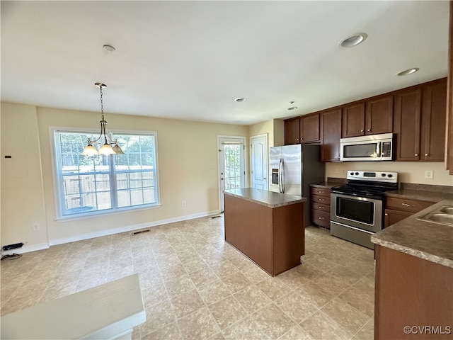 3000 Perdue Springs Ln, Chester, VA 23831 - kitchen with appliances with stainless steel finishes, a center island, decorative light fixtures, baseboards, and dark countertops