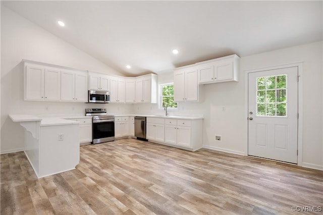 17513 Kathleen Ct, South Chesterfield, VA 23803 - kitchen with appliances with stainless steel finishes, a sink, a peninsula, light wood-style floors, and vaulted ceiling