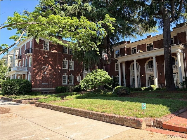 view of front of home with a front lawn and brick siding