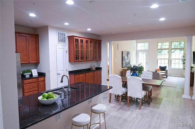 5801 Riverside Trl, Richmond, VA 23225 - kitchen featuring decorative columns, recessed lighting, glass insert cabinets, and light wood-type flooring