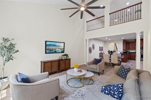 5801 Riverside Trl, Richmond, VA 23225 - living area featuring ornate columns, ceiling fan, a towering ceiling, baseboards, and light wood-type flooring