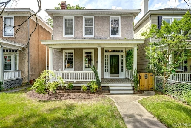 traditional style home with covered porch, stucco siding, and a chimney