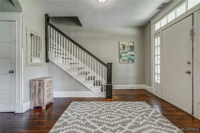 foyer entrance featuring hardwood / wood-style flooring, baseboards, and stairs