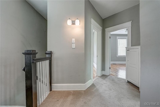 hallway with carpet floors and baseboards
