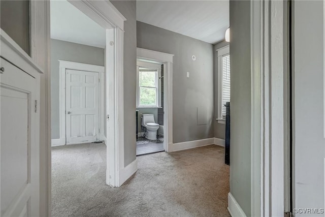 corridor with carpet flooring and baseboards