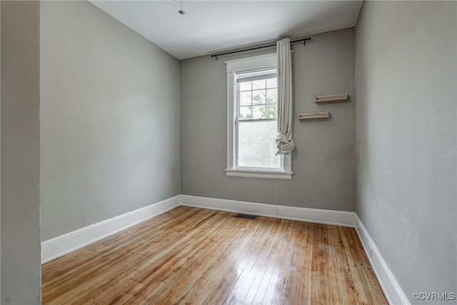 empty room featuring hardwood / wood-style flooring and baseboards