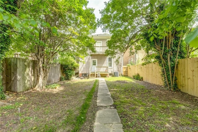 back of property with a fenced backyard, stucco siding, and central air condition unit