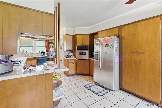 12060 Pinhook Rd, Hanover, VA 23146 - kitchen featuring stainless steel appliances, light tile patterned floors, tile countertops, and brown cabinets