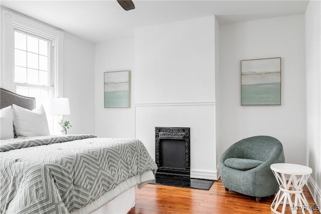 1517 Oakwood Ave, Richmond, VA 23223 - bedroom with wood finished floors, a fireplace with flush hearth, a ceiling fan, and baseboards