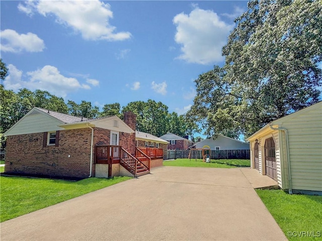 view of property exterior with brick siding, a chimney, a wooden deck, and driveway