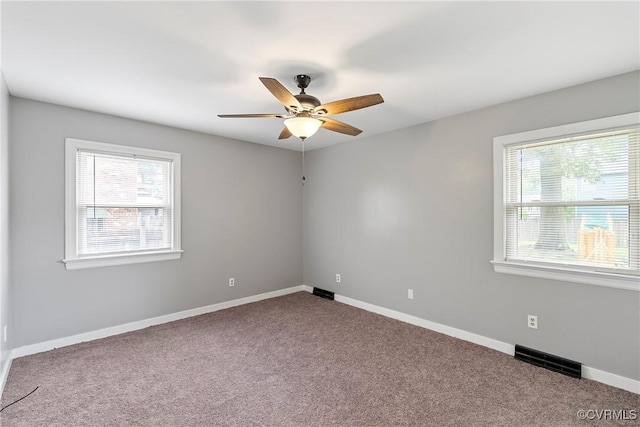 carpeted spare room featuring healthy amount of natural light, ceiling fan, and baseboards