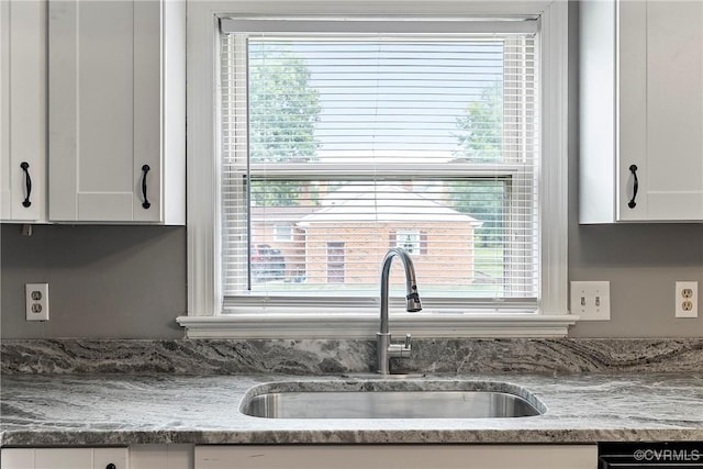 kitchen featuring a sink, healthy amount of natural light, and white cabinetry