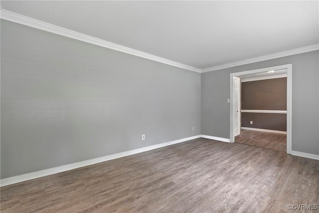 spare room with dark wood-style floors, ornamental molding, and baseboards