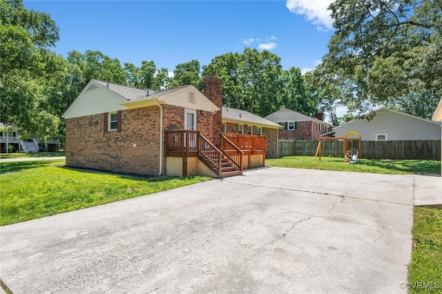 view of front of house featuring brick siding, a chimney, and driveway