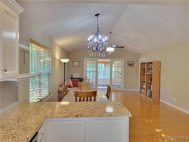 kitchen featuring open floor plan, white cabinetry, light wood-type flooring, lofted ceiling, and a peninsula