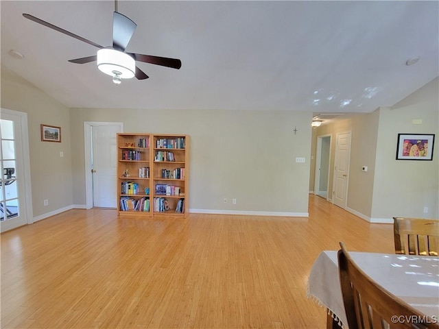 living area featuring vaulted ceiling, a ceiling fan, light wood-type flooring, and baseboards