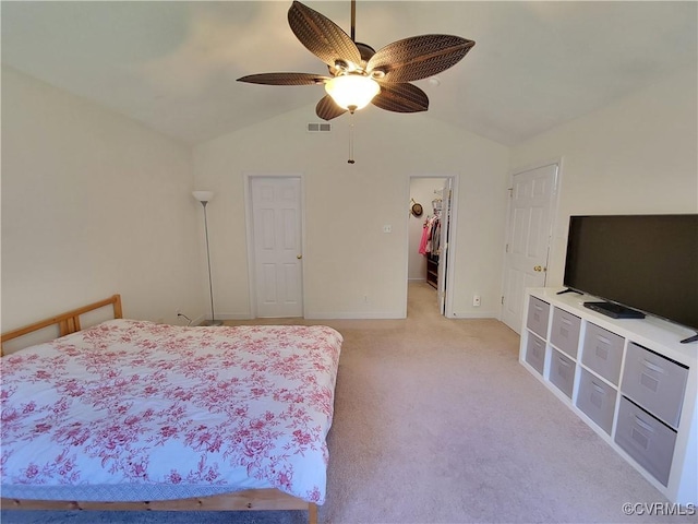 bedroom featuring lofted ceiling, light colored carpet, baseboards, a spacious closet, and a ceiling fan