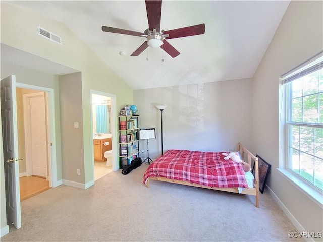 bedroom with lofted ceiling, carpet floors, multiple windows, connected bathroom, and baseboards