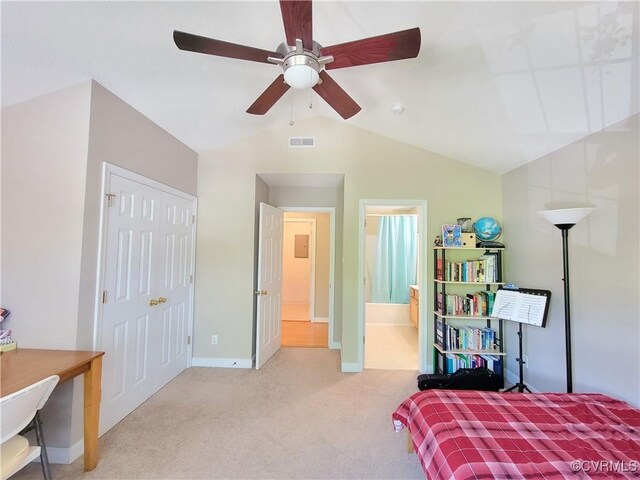 bedroom with carpet flooring, vaulted ceiling, baseboards, ensuite bath, and ceiling fan