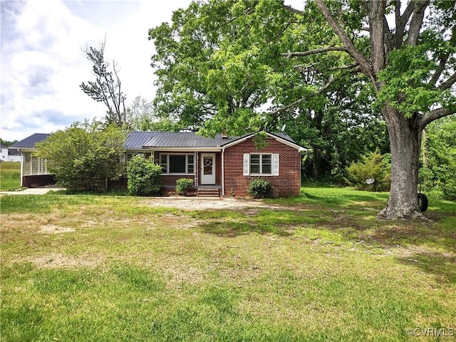 ranch-style house featuring a front yard, brick siding, and metal roof