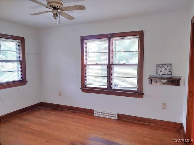 empty room with wood finished floors, baseboards, and ceiling fan
