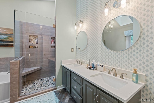 bathroom featuring a stall shower, double vanity, and wallpapered walls